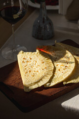 Qutab flatbreads on wooden board with glass of red wine
