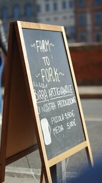 A blackboard with the words Farm to Fork written on it. The board is on a wooden stand
