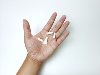 Pills in hand: A hand holding pills isolated, highlighting the importance of health, medication and...