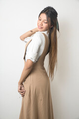 Elegant Female Model in Beige Designer Dress Against Minimal White Background