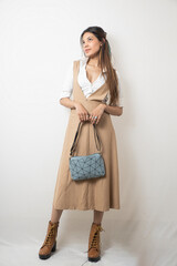 Elegant Female Model in Beige Designer Dress Against Minimal White Background