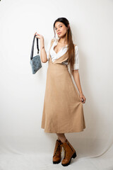 Elegant Female Model in Beige Designer Dress Against Minimal White Background