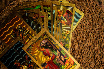 Tarot cards with gold accents lie on burlap. 