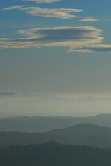Silhouettes of hills and high clouds in the sky