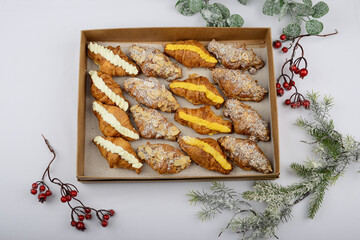 Croissants with different fillings in a box on a white background with decor