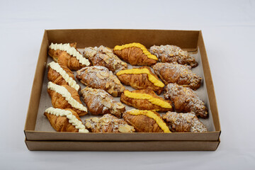 Croissants with different fillings in a box on a white background
