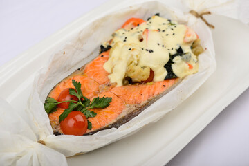 baked salmon fillet with sauce in parchment