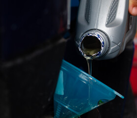 The process of changing engine oil by adding and pouring new, clear, quality engine oil into the motorcycle engine. Engine maintenance system and fuel energy concept.