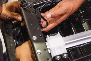 A skilled technician man assembling and checking the electrical system and internal mechanism of an...