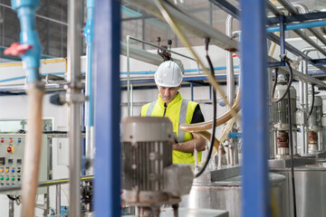 Engineers or factory managers wearing safety helmet inspect the machines in the production line....
