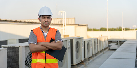 Portrait Asian maintenance engineer works on the roof of factory. contractor inspect compressor...