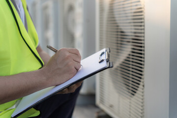 Asian maintenance engineer works on the roof of factory. contractor inspect compressor system and...