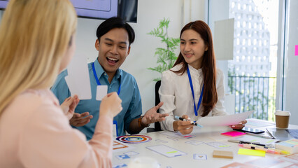 ux, ui, web and mobile app designers are discussing the look and feel of the website or app they are designing including color schemes and layouts to make it easy and enjoyable for users