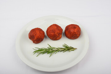 Cheese balls in batter on a white plate on a white background