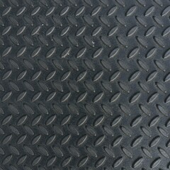Close-up of black industrial diamond plate texture, used for flooring, backgrounds, and heavy-duty non-slip surfaces.