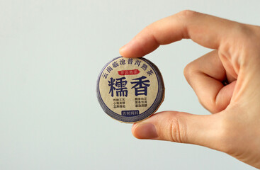 hand holding a package of traditional chinese tea served at tea ceremony, isolated on white
