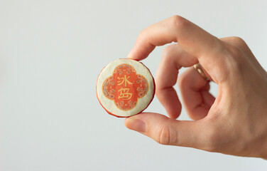 hand holding an orange package of traditional chinese tea for tea ceremony