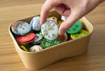 a hand taking a disc of compressed chinese tea from a box with multiple types of tea