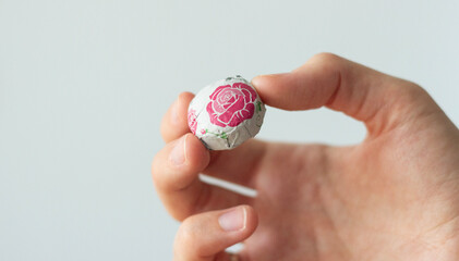 hand holding a package of compressed chinese tea with roses isolated on white
