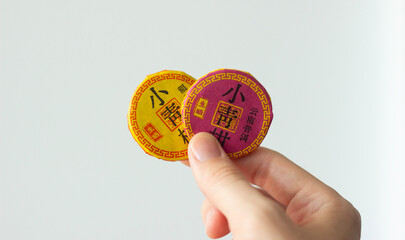 hand holding two packages of traditional chinese tea, one green and one black, served for chinese...