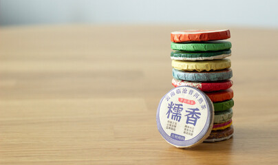 a column composed of compressed traditional chinese tea in round bricks, isolated on the table