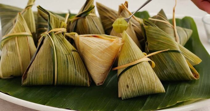 Triangle-shaped food parcels wrapped in dried leaves