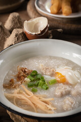 Close-up of rice porridge or pork congee for breakfast, boiled eggs, fried dough sticks, soft-boiled eggs.