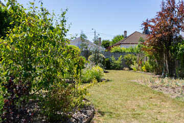 Jardin paysager aménagé par une entreprise spécialisée, avec pelouse, massifs fleuris, arbustes décoratifs.