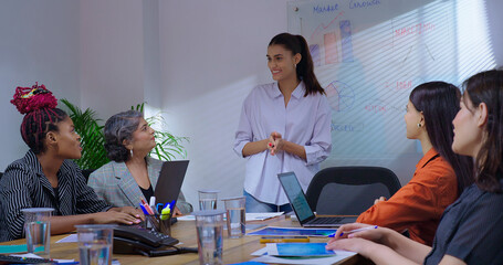 Indian young female old boss lady team leader show chart white board learn study graph data growth...