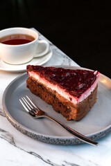 Slice of Chocolate Raspberry Cake. Tea on Elegant Marble Surface