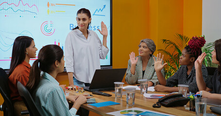 Indian young female old boss lady team leader show chart white board learn study graph data growth work place adult girl talk speak share stock trade idea plan staff group raise hand job office day