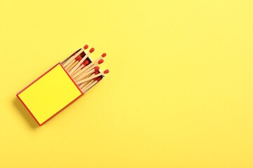 Matches in box on yellow background, top view. Mockup for design