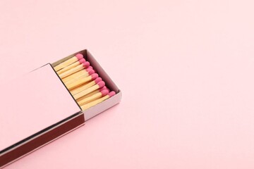 Matches in box on pink background, closeup. Mockup for design