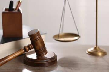 Judge. Gavel and scales on wooden table in office, closeup