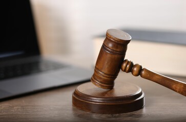Judge. Laptop and gavel on wooden table in office, closeup