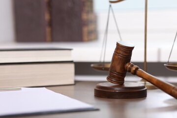 Judge. Gavel, scales, clipboard and books on wooden table in office, selective focus