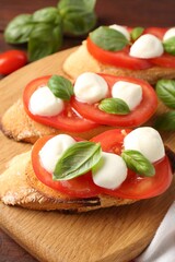 Tasty sandwiches with mozzarella cheese, tomatoes and basil on table, closeup