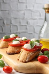 Tasty sandwiches with mozzarella cheese, tomatoes and basil on table, closeup