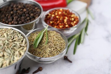Different aromatic spices on white table, closeup