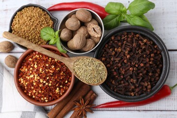 Different aromatic spices on white wooden table, flat lay