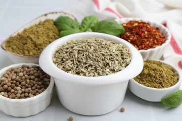 Different aromatic spices on white tiled table, closeup