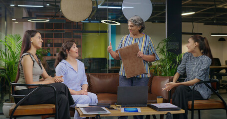 Indian old aged boss lady hold file do share good news new deal work talk speak ideas plan job...