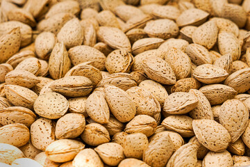 A rustic pile of unshelled almonds (Prunus dulcis) showcases earthy textures and natural tones&mdash;ideal for illustrating healthy eating, organic snacks, or plant-based nutrition themes.