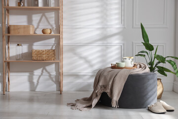 Stylish pouf with tea set at home