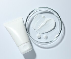 Cosmetic product in Petri dish and tube on white background, top view