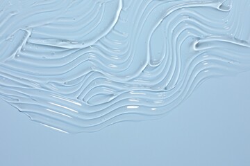 Sample of cosmetic product on light blue background, closeup