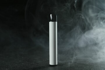 Modern electronic smoking device on black table