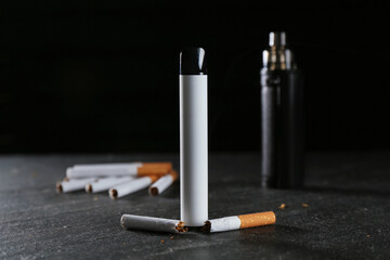 Electronic smoking devices and cigarettes on black table