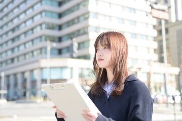 バインダーを持って笑顔の日本人女性