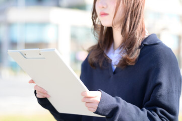 バインダーを持って笑顔の日本人女性